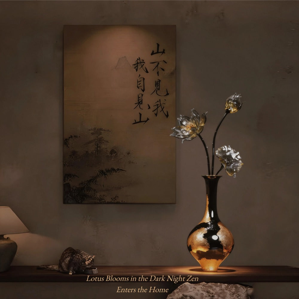 Decorative setup with a vase of luxury glass lotus flowers, and a piece of art on a wall.