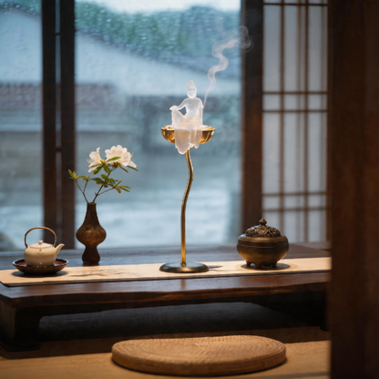 Decorative scene with aincense burner, teapot, and flowers on a wooden table.